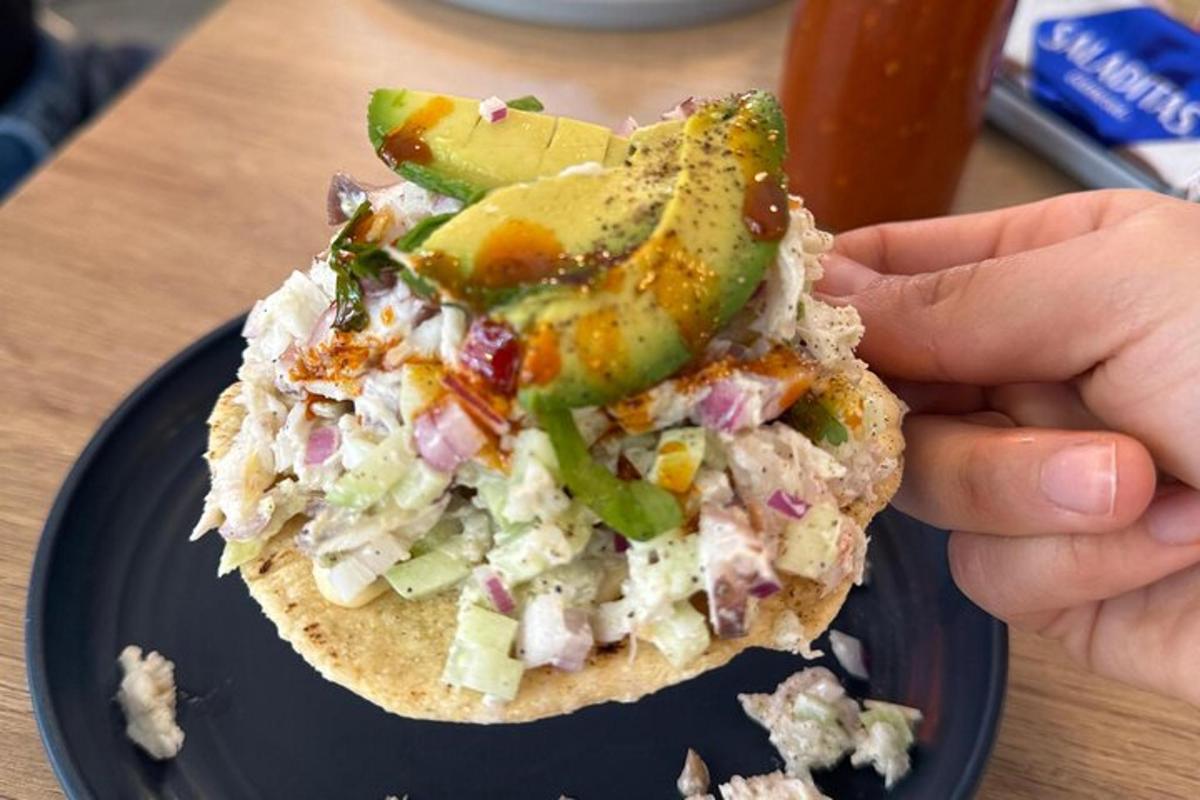 a person holding a piece of food on a plate