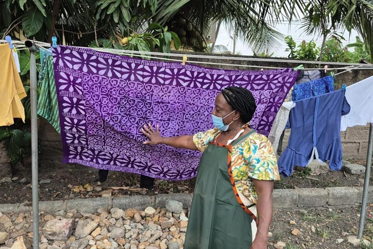 a woman wearing a mask standing in front of a towel