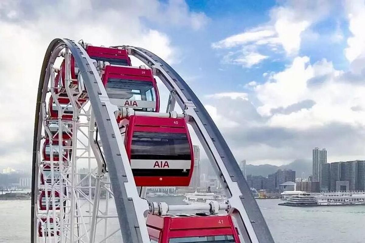 o roată mare cu două autobuze roșii și albe pe ea