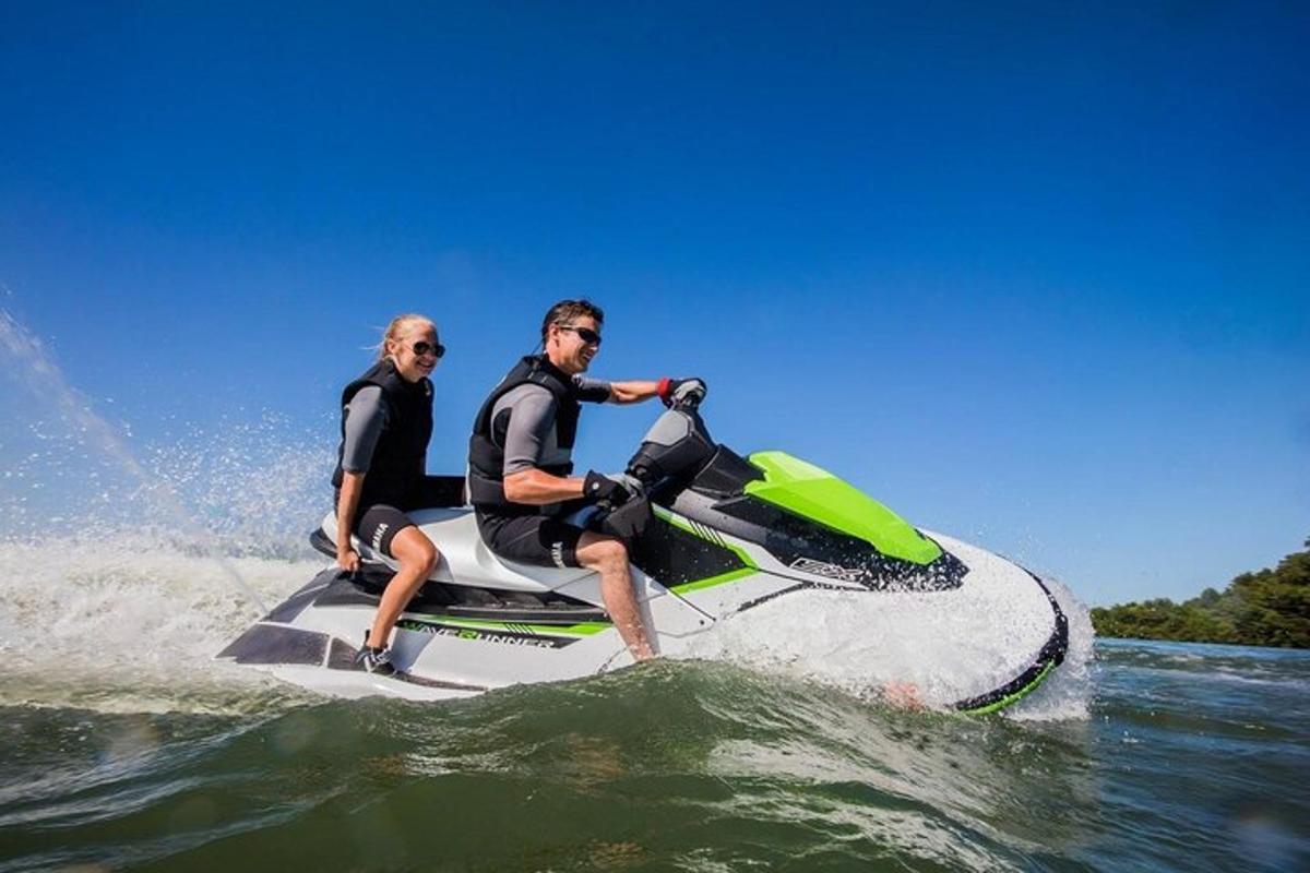 two men riding on a jet ski in the water