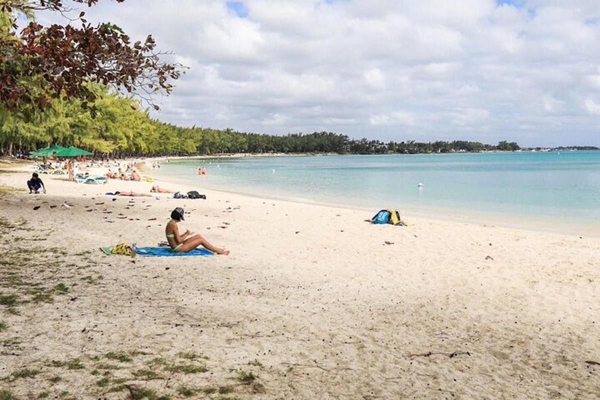 una persona seduta su una spiaggia vicino all'acqua
