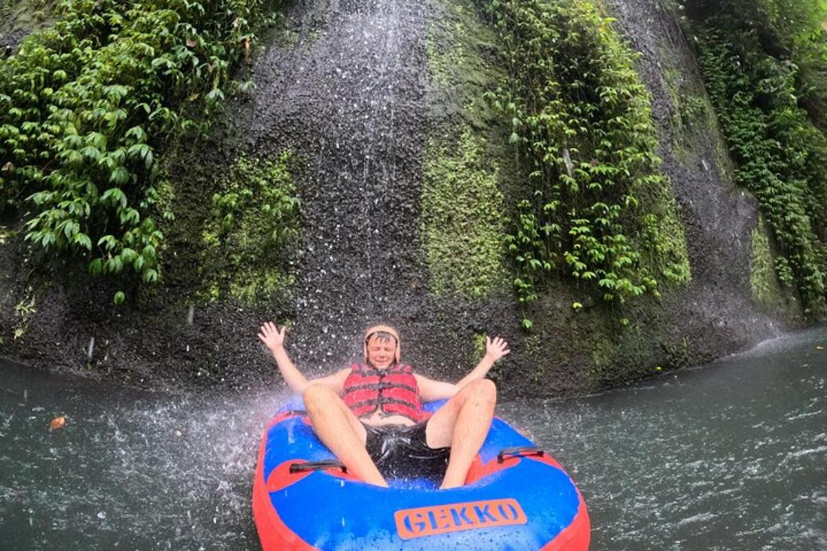 seorang lelaki menaiki rakit di air terjun