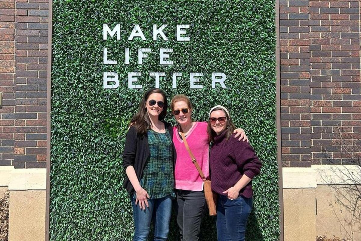 three women standing in front of a wall with the words make life better