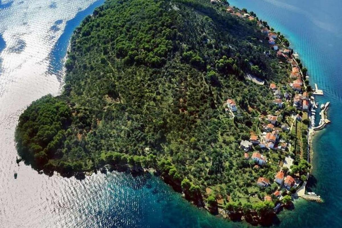 an island in the ocean with a group of houses on it