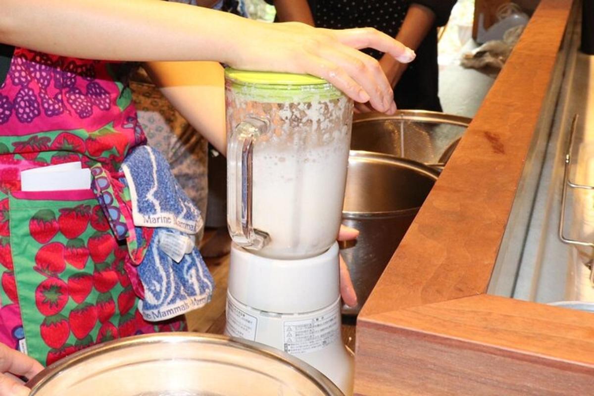 en person bruker en blender på en benk