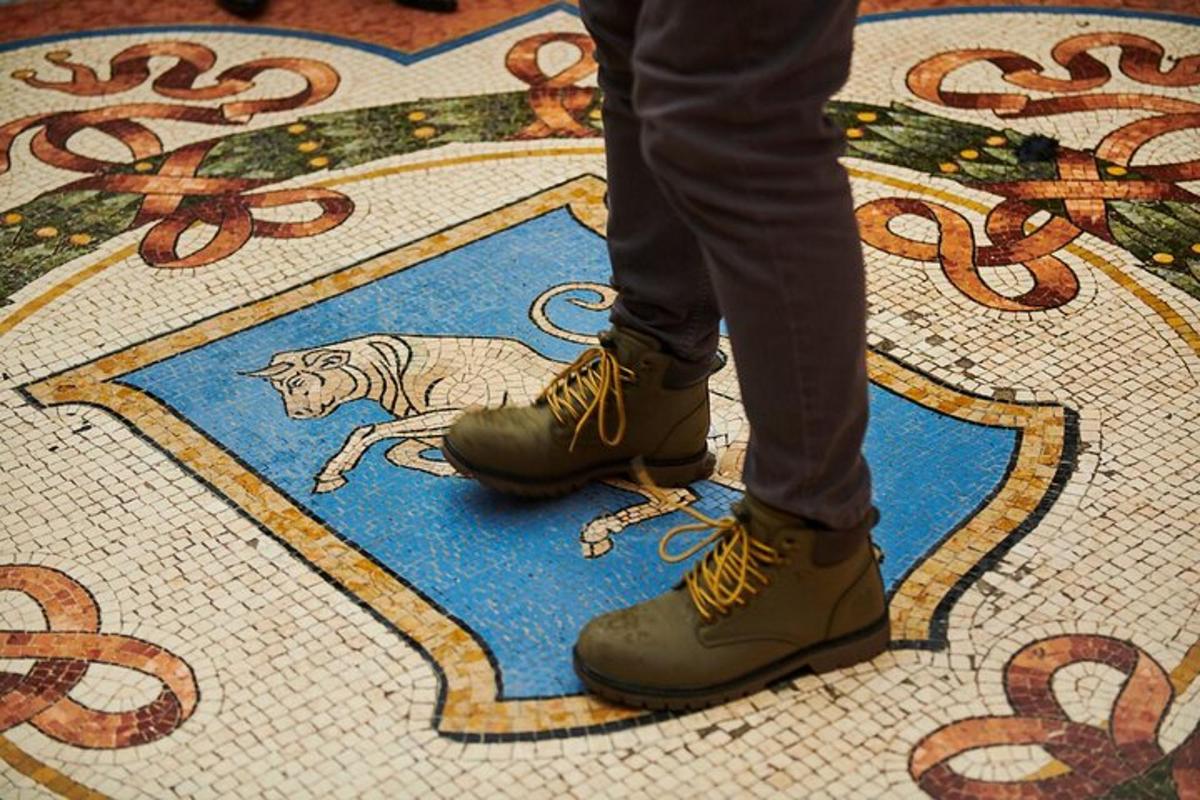 uma pessoa usando botas em um piso de ladrilho com um gato nele