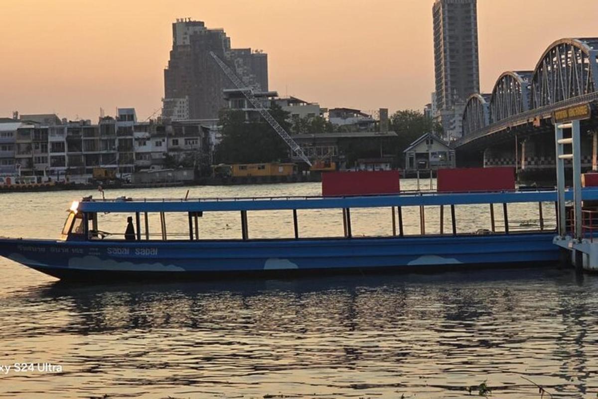 bot biru di dalam air di sebelah jambatan