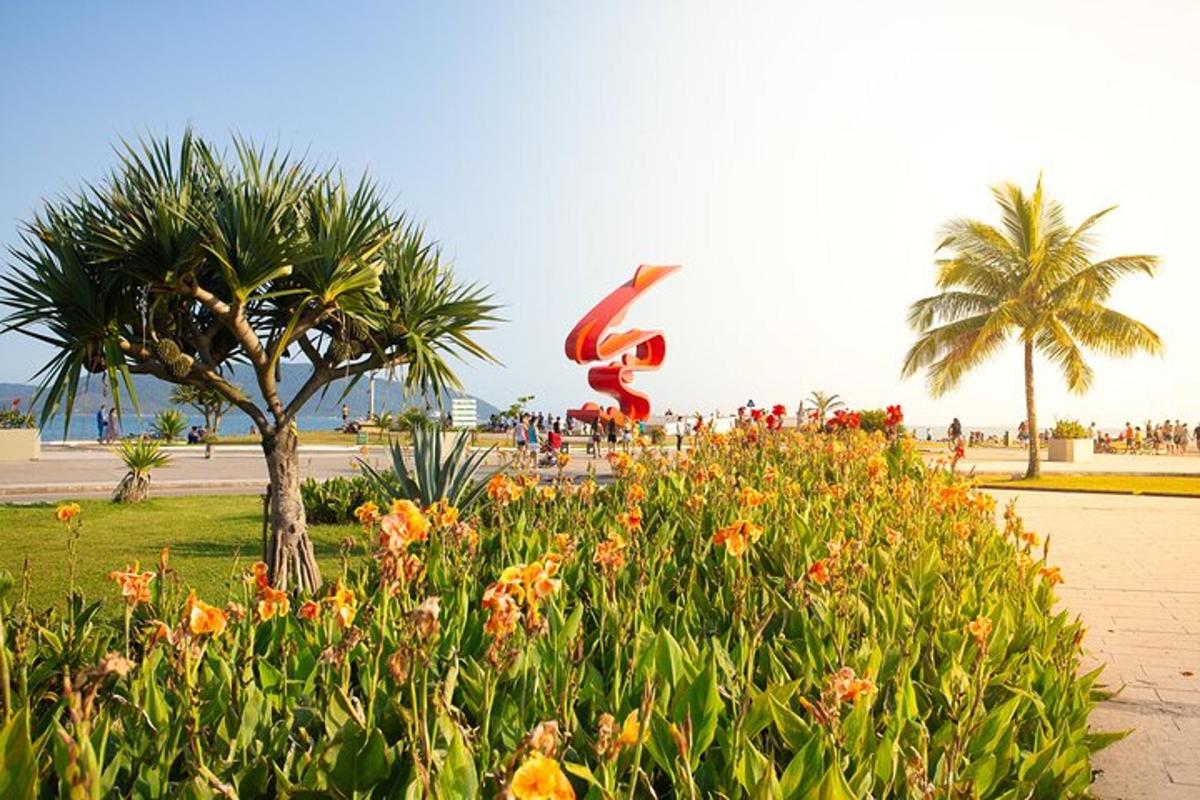 a sculpture in a park with flowers and palm trees