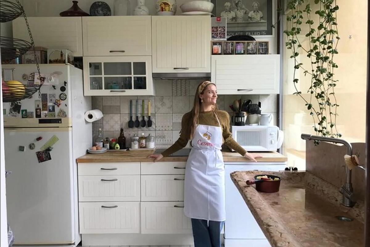 žena stojící v kuchyni v bílé zástěře