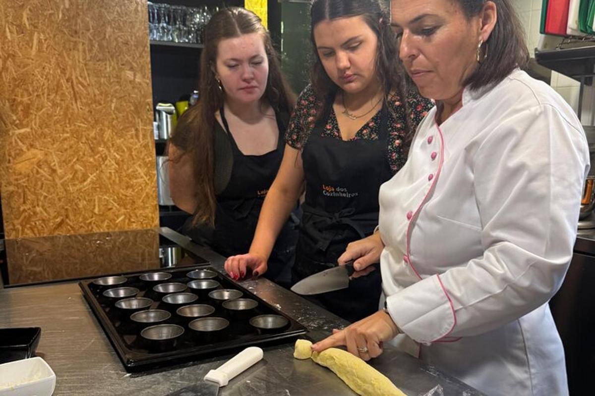 two women standing in a kitchen preparing cupcakes