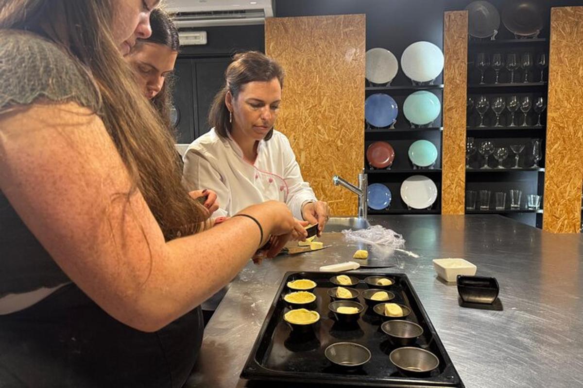 two women standing in a kitchen preparing cupcakes