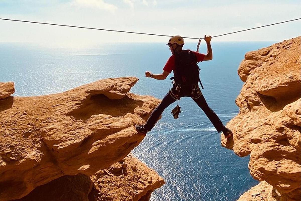moški visi na vrvi na pečini