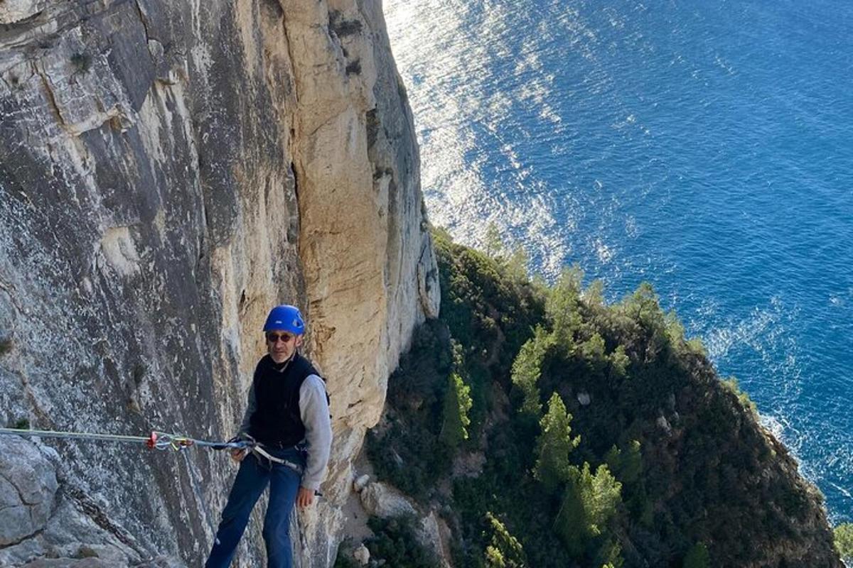 um homem em pé em um penhasco com uma corda