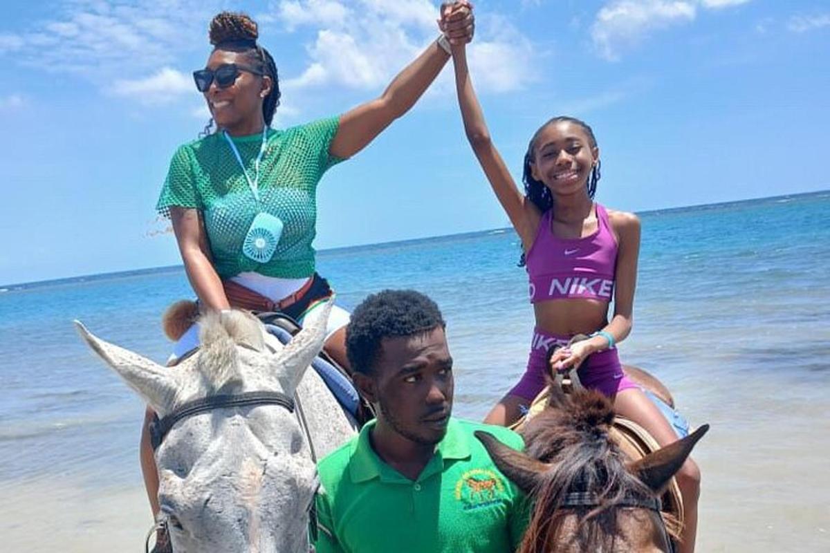 un uomo e una donna a cavallo sulla spiaggia