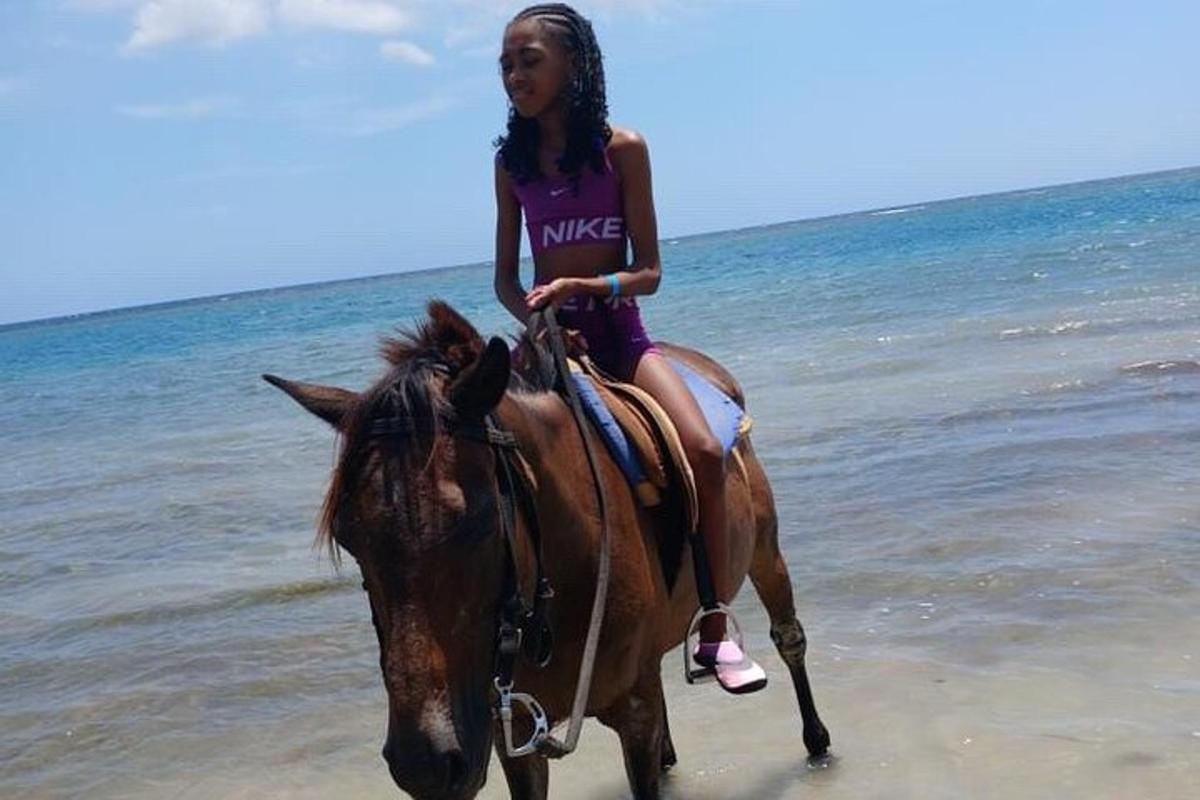 una giovane ragazza a cavallo sulla spiaggia