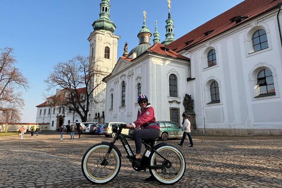 osoba jedoucí na kole před budovou
