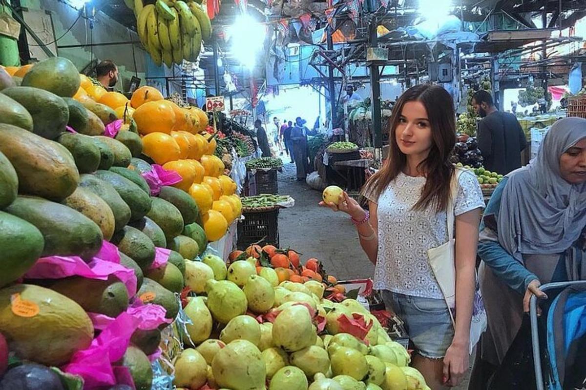 una dona està dreta en un mercat de fruites