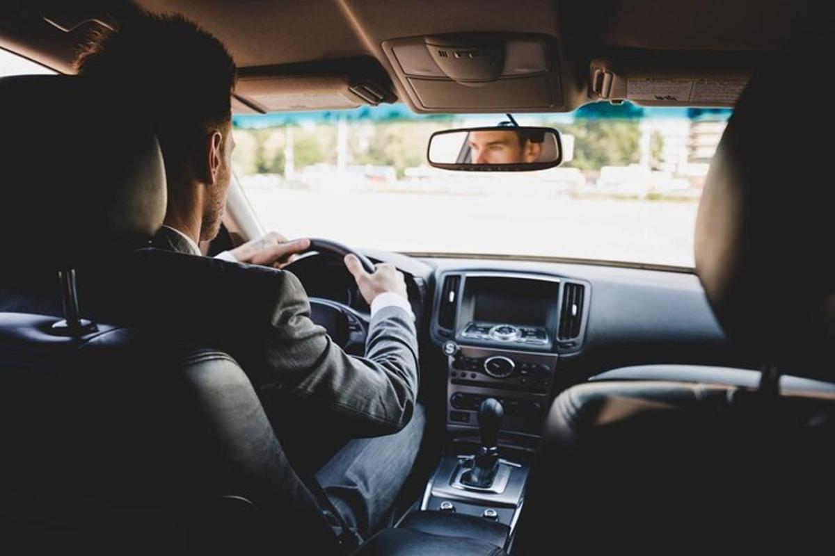a man sitting in a car looking at his cell phone