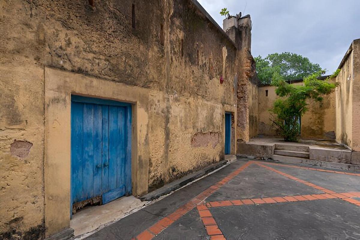 an alley with two blue doors on the side of a building