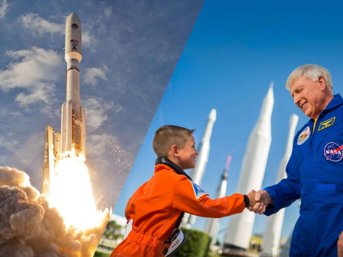 a man shaking the hand of a boy in front of a rocket
