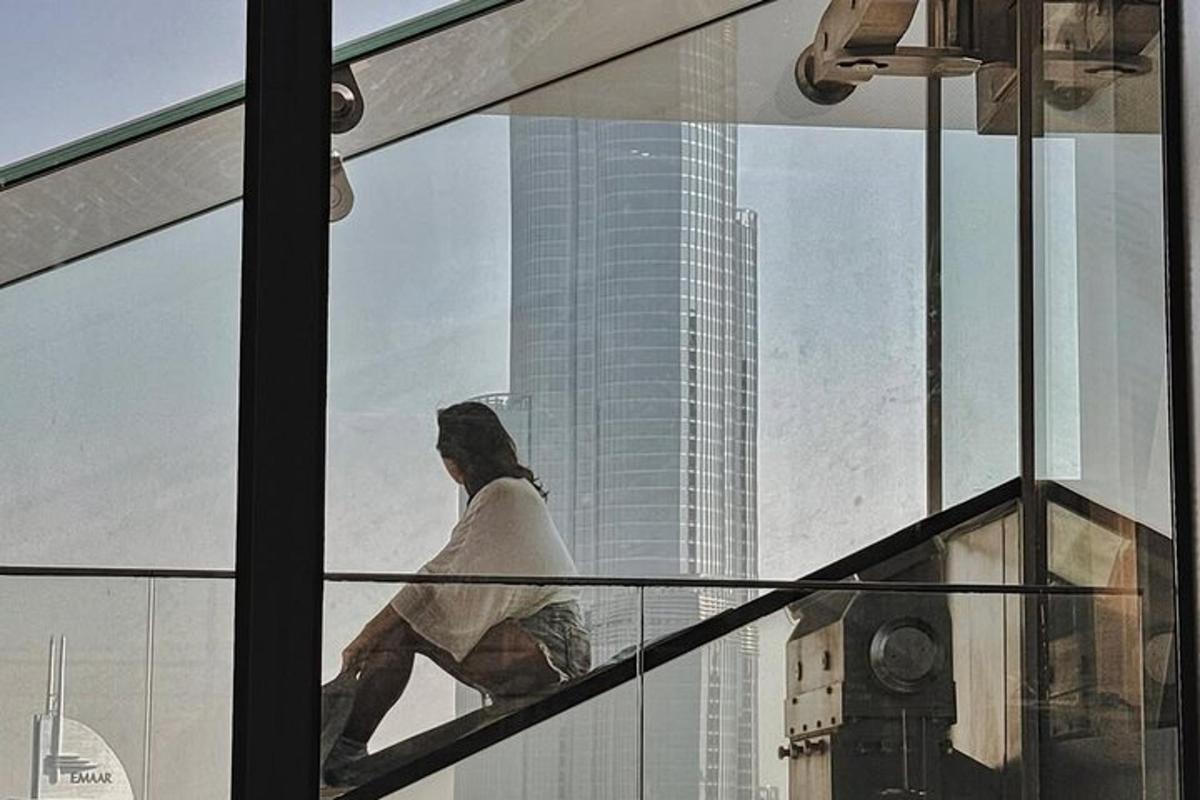 a man is walking down a glass window