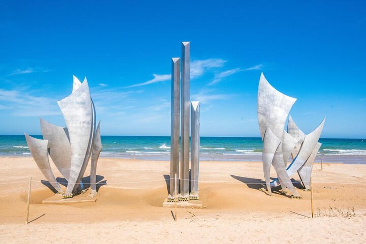 a sculpture on a beach with the ocean in the background
