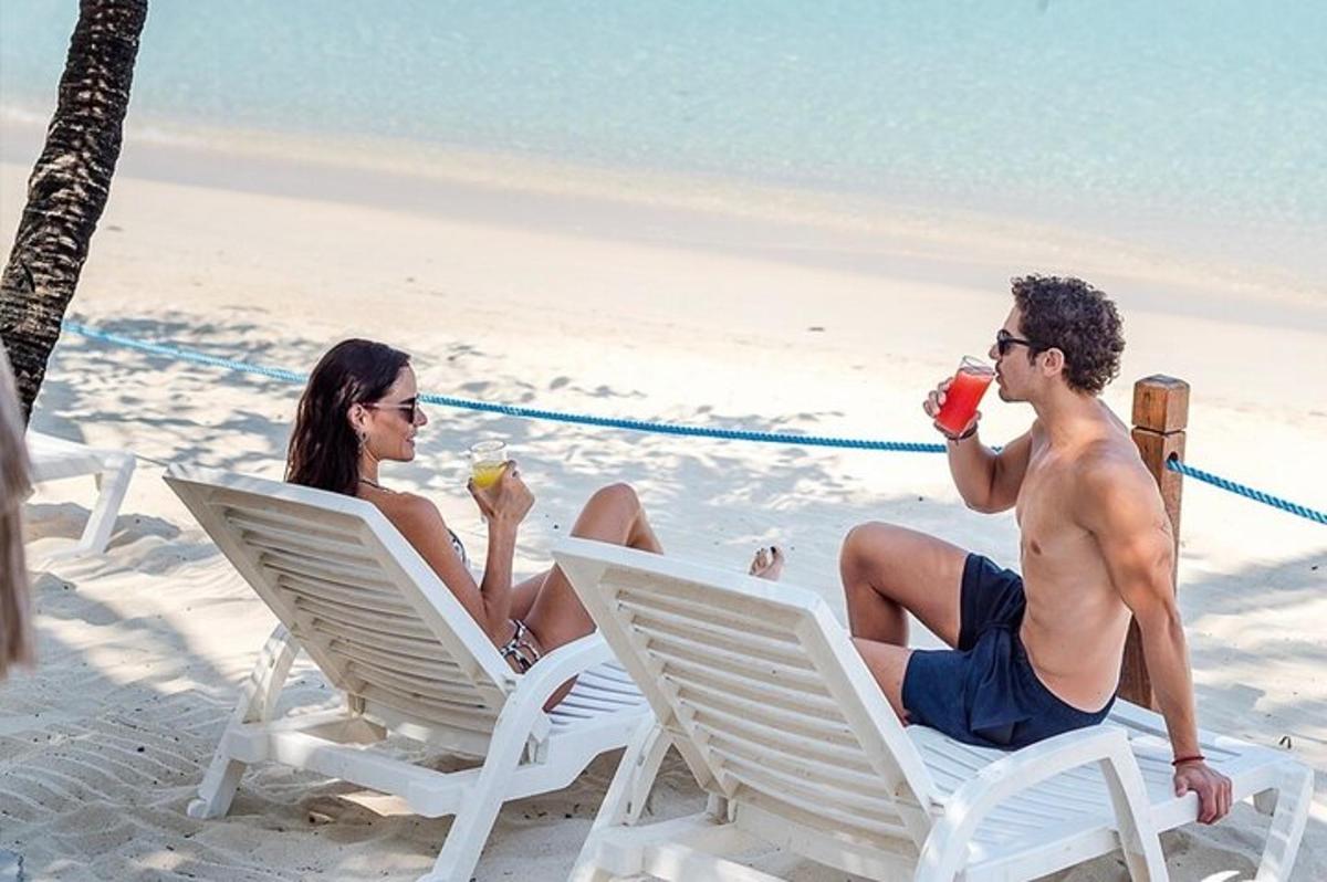 a man and a woman sitting in chairs on the beach