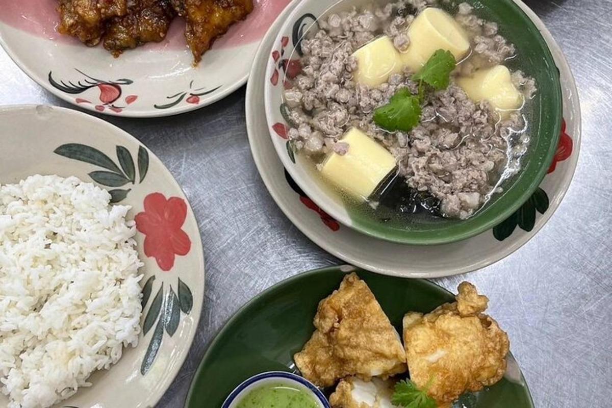 a table with three plates of food and rice