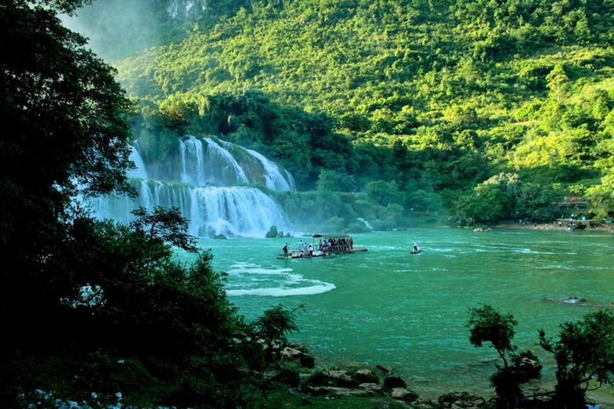 a boat in the river near a waterfall