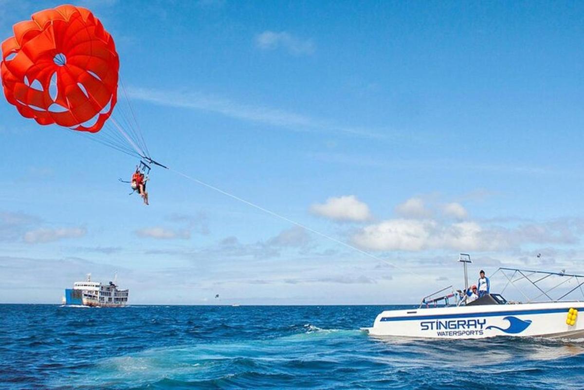 Una persona está siendo arrastrada por un paracaídas en un barco en el océano.