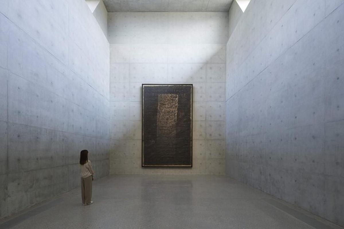 uma mulher olhando para uma pintura em um museu de arte