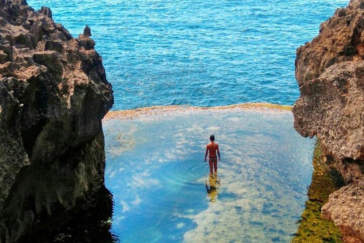 un uomo in piedi nell'acqua tra due rocce