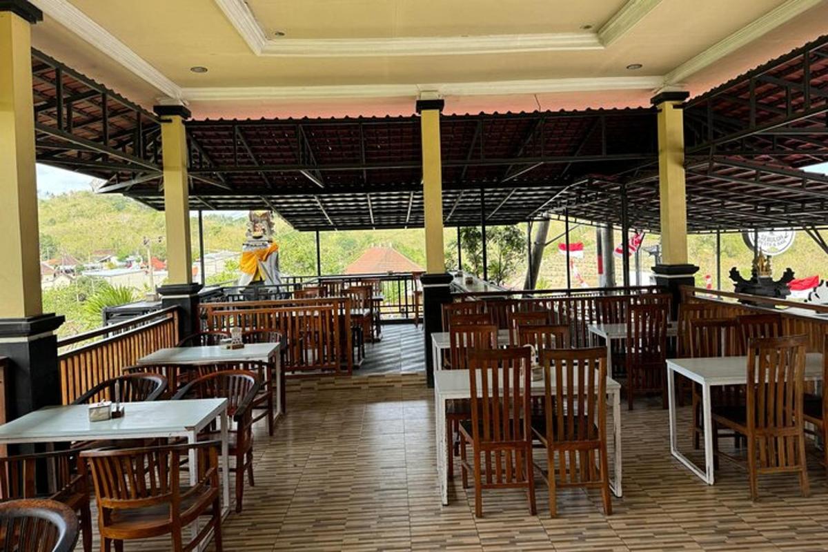 un ristorante vuoto con tavoli e sedie e una persona sullo sfondo
