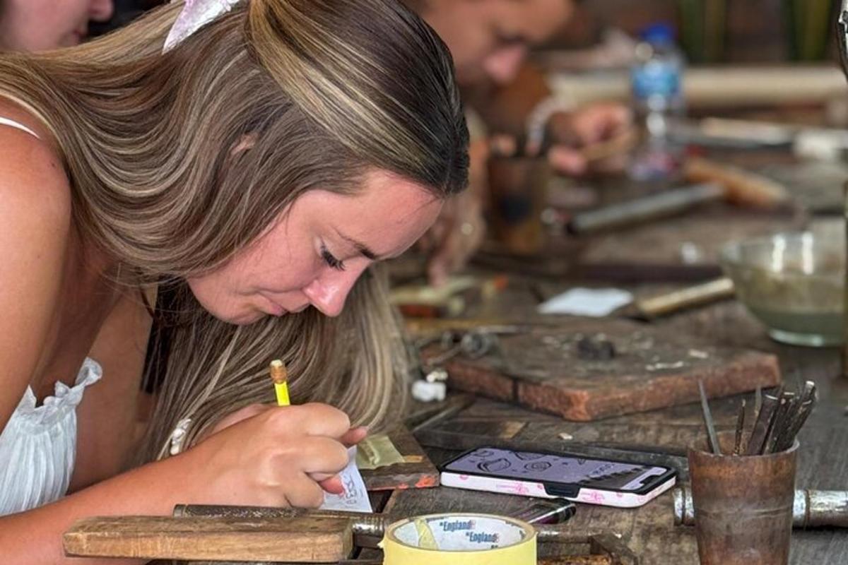 egy nő ül egy asztalnál, ceruzát tartva a kezében