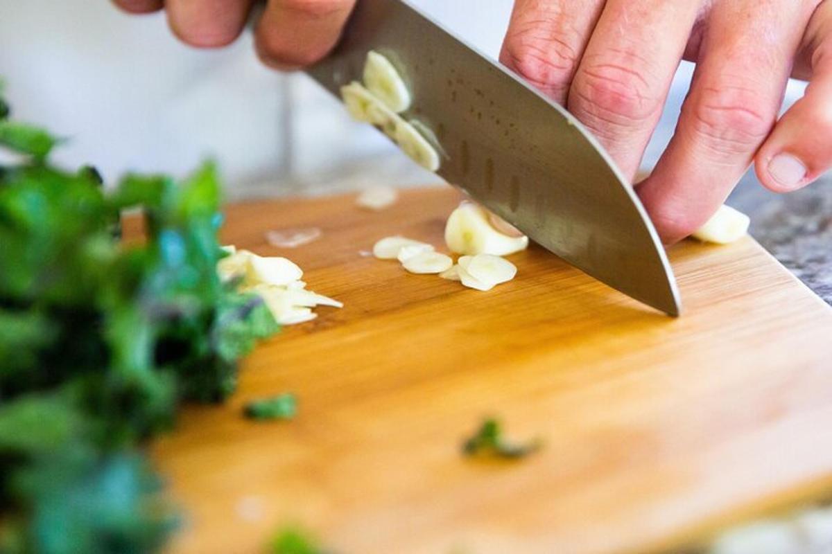 a person cutting up garlic on a cutting board with a knife