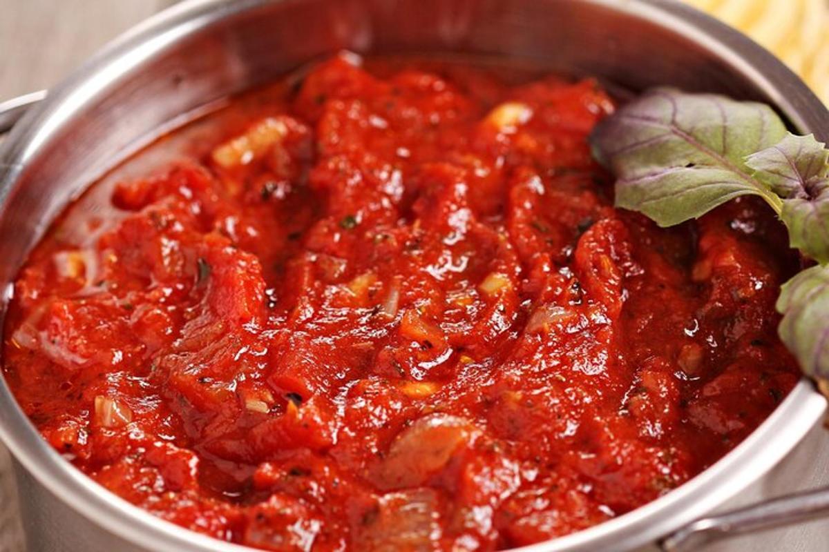 a pot of tomato sauce with a plant in it