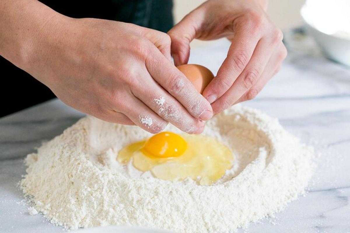 a person holding an egg on top of flour