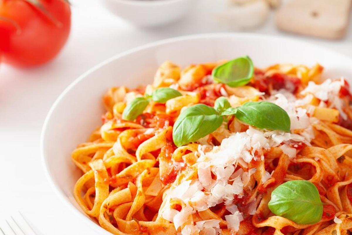 Un tazón de pasta con queso y albahaca.