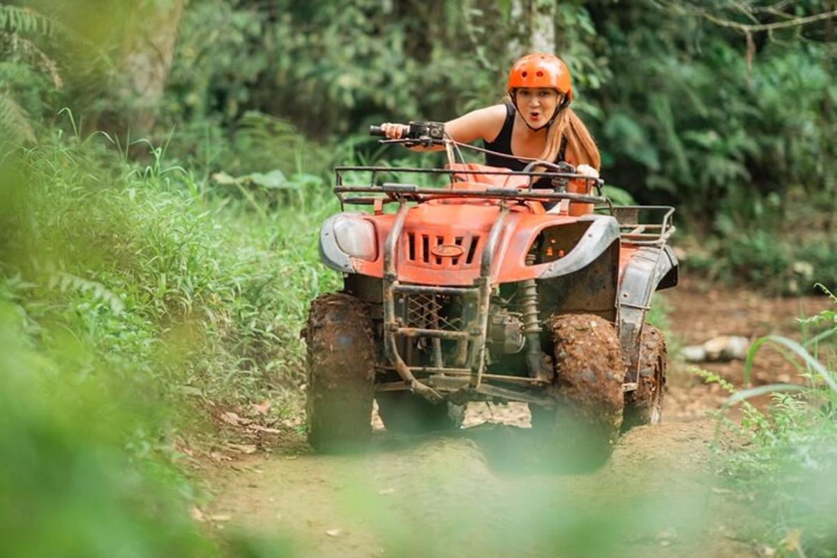 žena vozi ATV niz zemljanu stazu