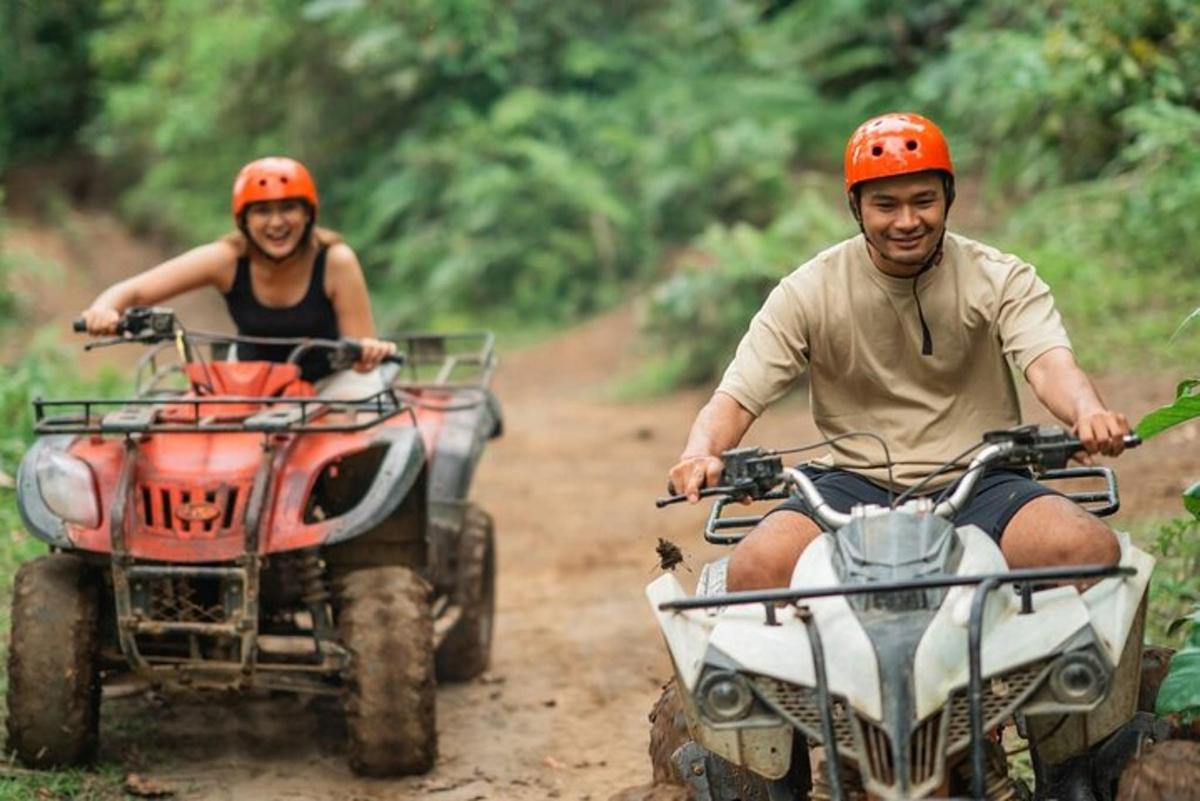muškarac i žena voze se na ATV-ima po zemljanom putu