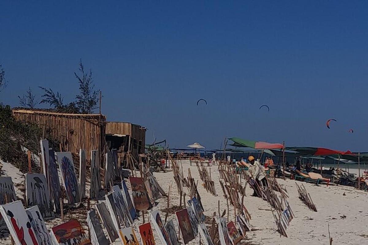 a beach with chairs and umbrellas on the sand