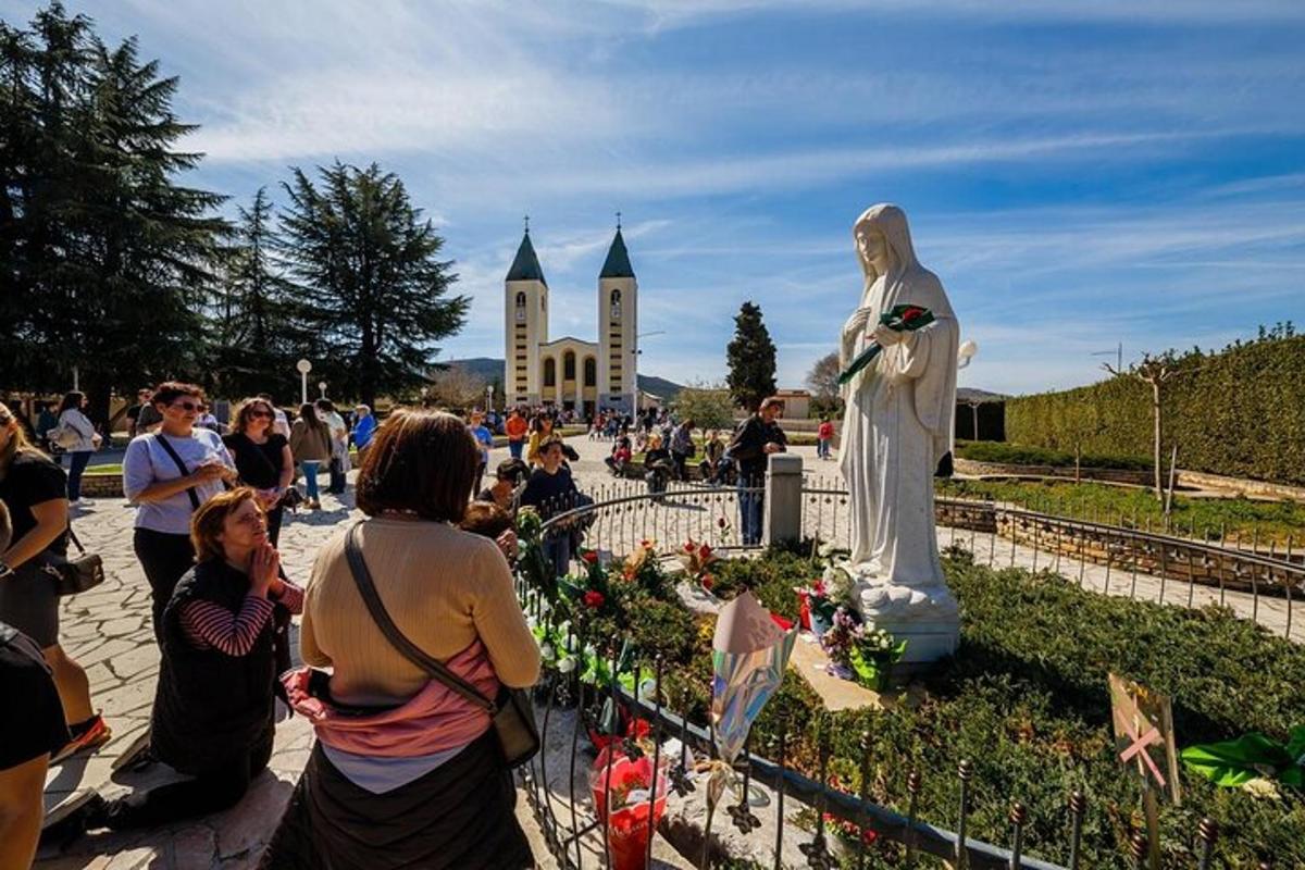 una multitud de persones mirant una estàtua d'un home