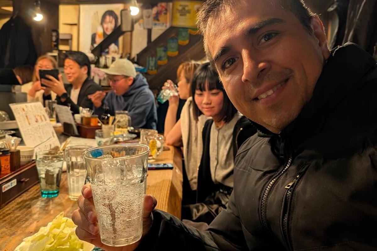 a man holding a glass of water at a bar