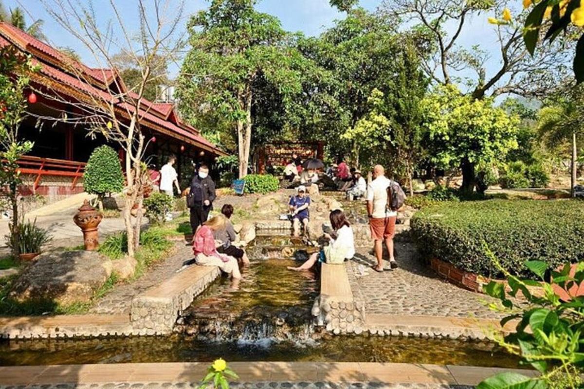 sekumpulan orang duduk di sekeliling kolam di taman