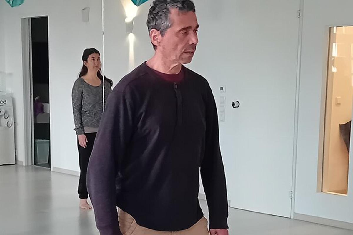 een man die in een kamer staat met een vrouw achter hem