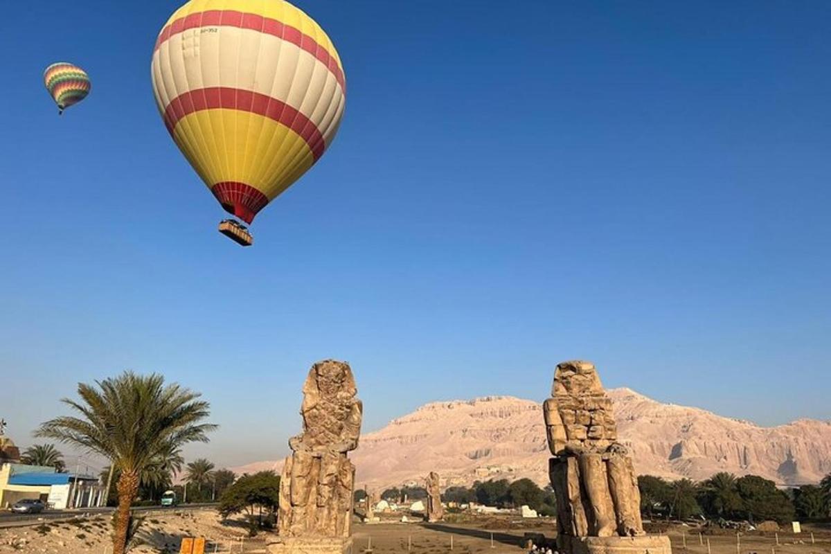 una mongolfiera che vola sopra due statue