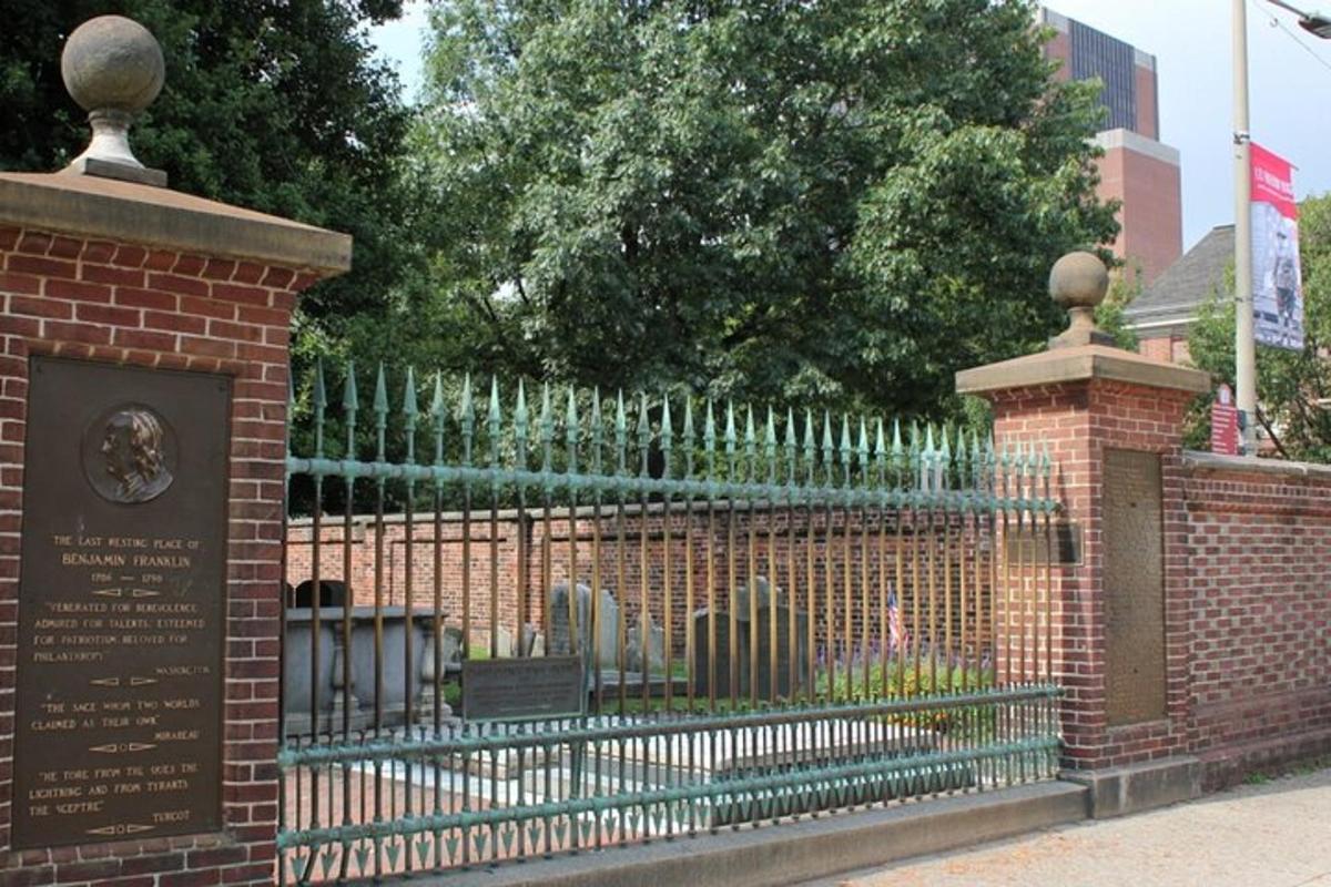 una recinzione in ferro battuto con un cimitero dietro