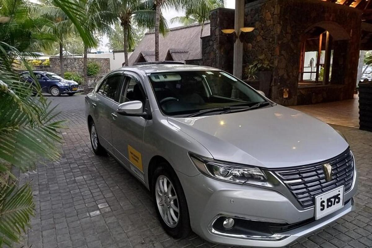 um carro prateado estacionado em frente a uma casa