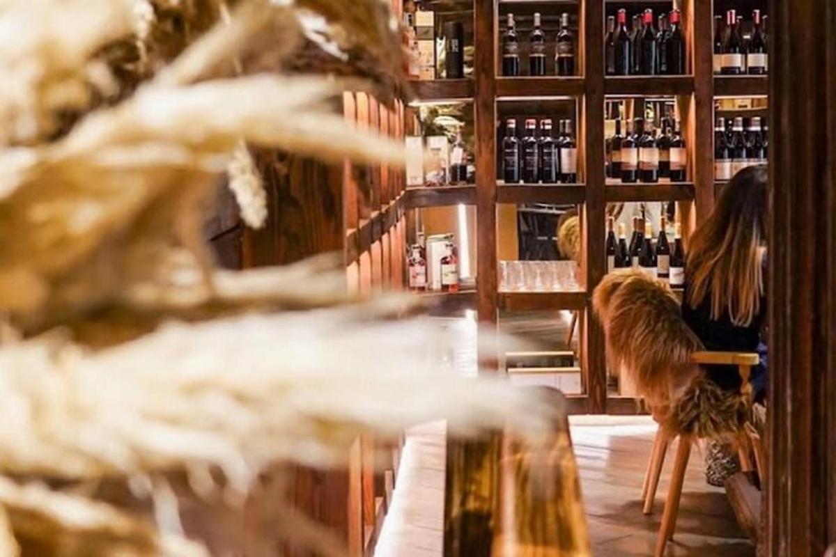 một người phụ nữ đang ngồi ở quầy bar trong một cửa hàng rượu