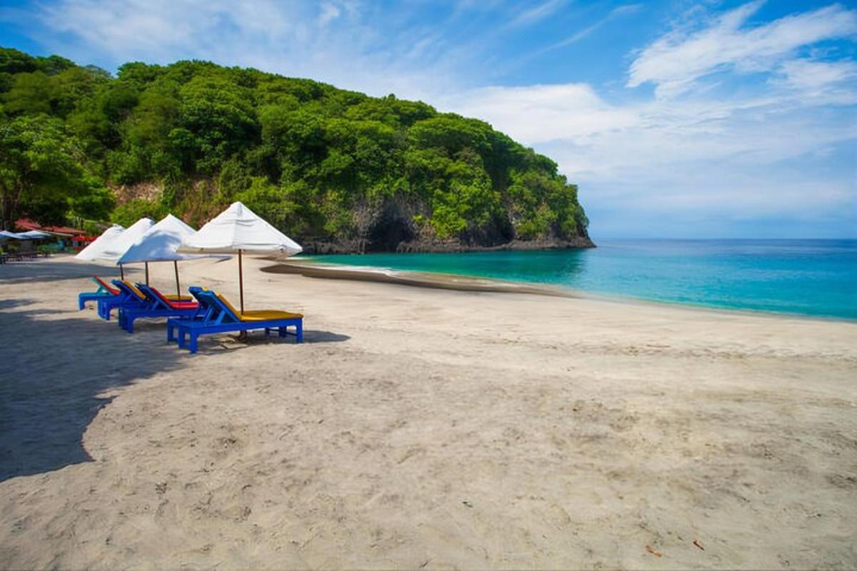 tiga kerusi dan payung di pantai dengan lautan